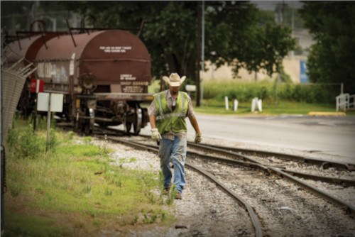 man walking in a railroad field