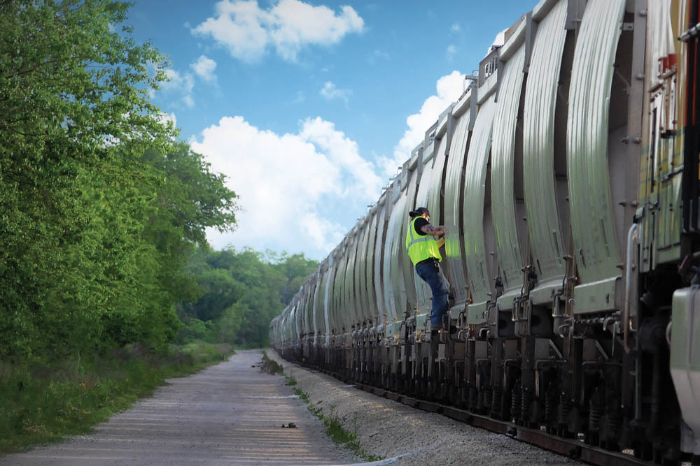 field worker stepped up on set of railway cars